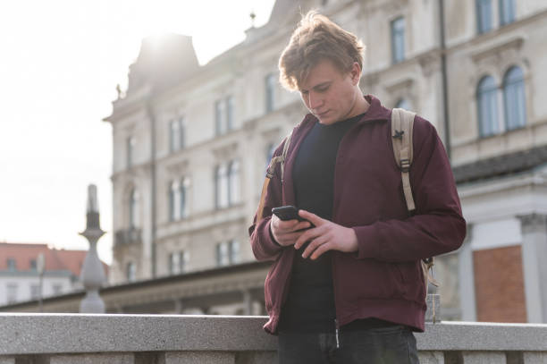 istock Backpacker walking through the city and using his phone 1393662373