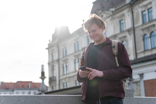 istock Backpacker walking through the city and using his phone 1393662390