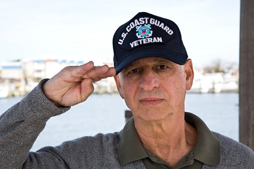 Senior male U.S. Coast Guard military veteran wearing veterans cap.