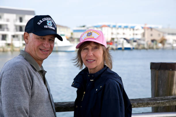 Senior male and female U.S. Coast Guard military veterans wearing veterans cap.