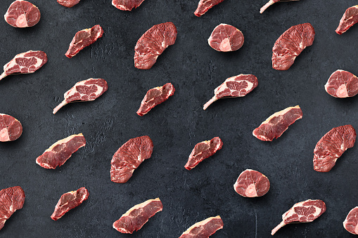 Pattern of Fresh raw beef meat and steaks on black background, top view