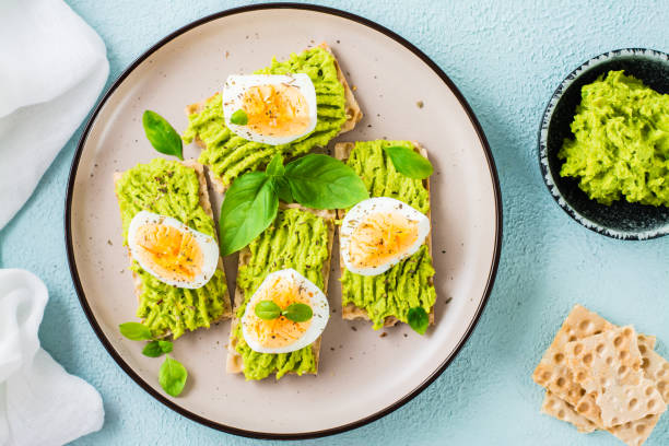 サクサクのパンにアボカドとゆで卵を皿に盛ったブルスケッタ。トップビュー。クローズ アップ - sandwich breakfast boiled egg close up ストックフォトと画像