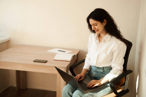 istock Cheerful girl enjoying friendly video call on laptop computer using web camera for communicating. Video communication with colleagues at home. 1393668967