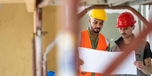 istock Technicians holding large paper and reading drawing, structure of scaffolding 1393669304