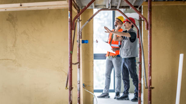 istock Supporting structure of scaffolding at doors to next room, two professionals discussing 1393669310