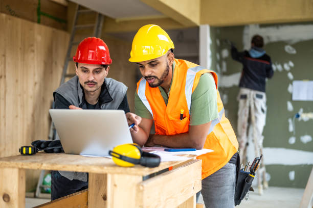 istock Engineers reading documentation on laptop, wearing safety equipment 1393669363