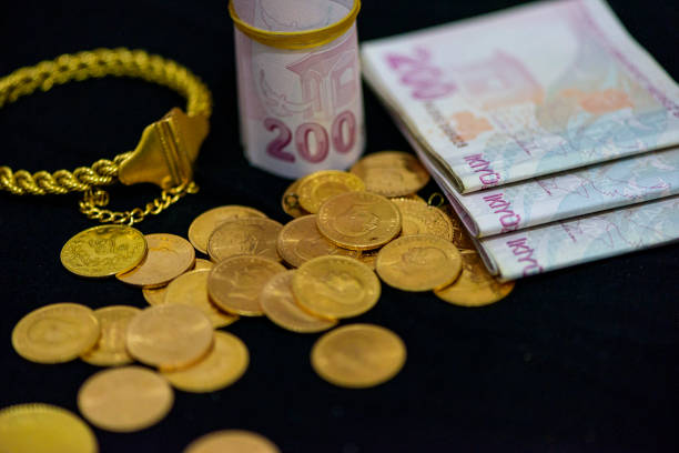 istock 200 Turkish lira and gold coin regularly stand on black background 1393670254