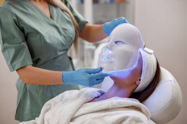 procedura cosmetica con maschera facciale a led per il viso femminile. terapia fotonica - plastic protective glove wrinkle treatment medical instrument foto e immagini stock