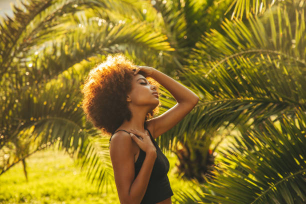 istock Pretty young afro woman among palm trees 1393672331