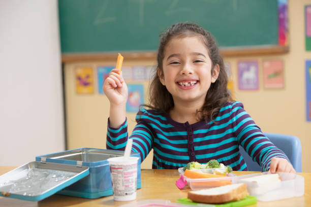 Little girl eating healthy at school stock photo