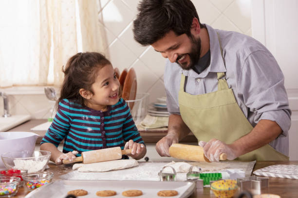 istock Little girl and father baking in the kitchen 1393673950
