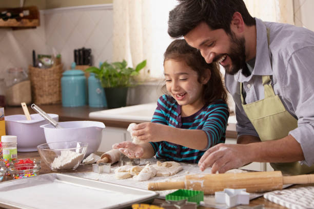 istock Little girl and father baking in the kitchen 1393673981