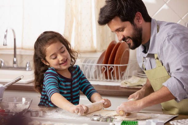 istock Little girl and father baking in the kitchen 1393674019