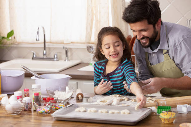 istock Little girl and father baking in the kitchen 1393674022