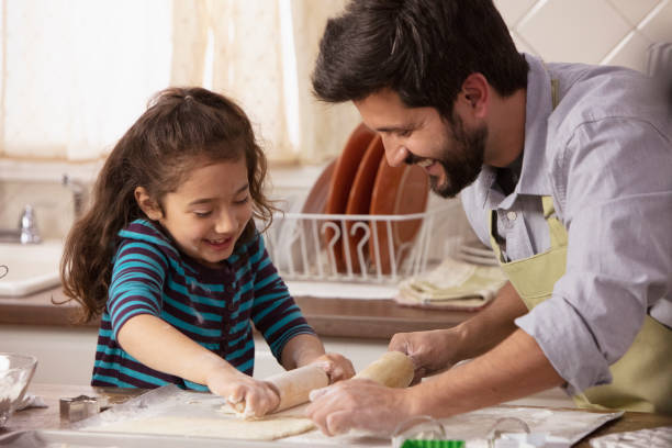 istock Little girl and father baking in the kitchen 1393674034