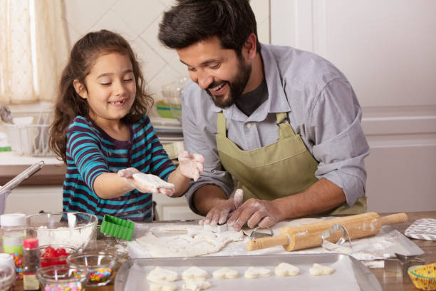 istock Little girl and father baking in the kitchen 1393674053