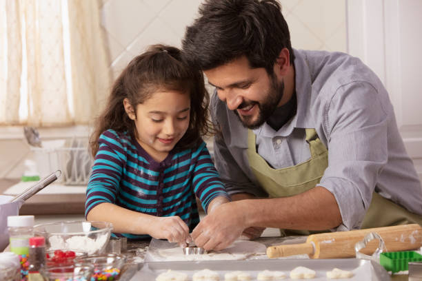 istock Little girl and father baking in the kitchen 1393674060