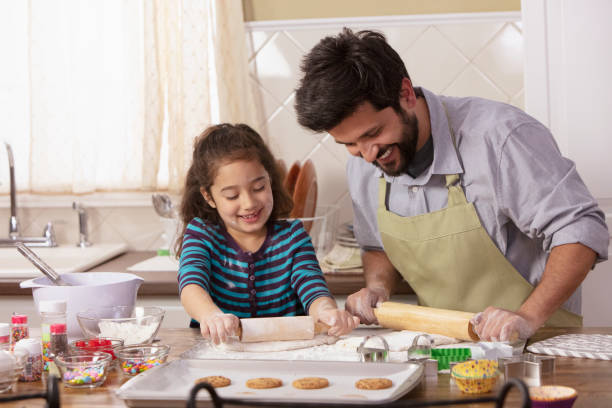 istock Little girl and father baking in the kitchen 1393674070