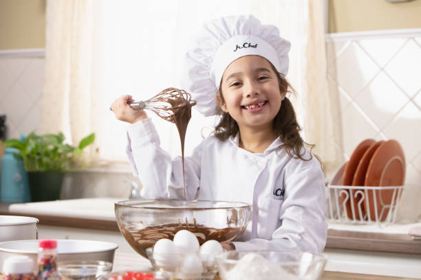 Little girl baking some cookies stock photo