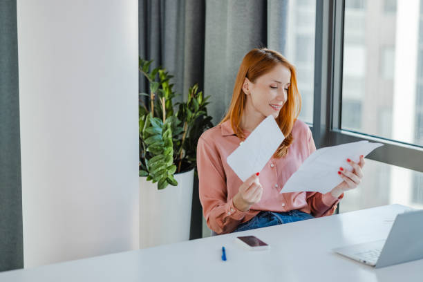 istock Young businesswoman looking at project papers 1393678085