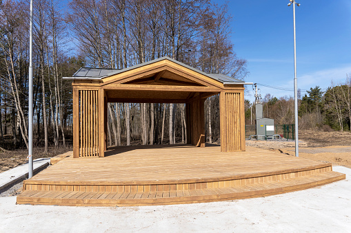 wooden gazebo stage built in a city park. a platform for performances and dances in the park