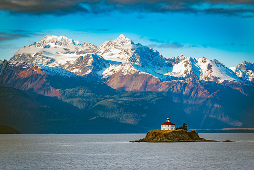 View of the Eldred Rock Lighthouse, a historic lighthouse adjacent to Lynn Canal in Alaska. It is the end of October with fresh snow on the mountains in the background. This wooden octagonal lighthouse was opened in 1905 and is 56 feet in height. The nearest city is Haines, Alaska which is reached by ferry from the south or by highway from the Yukon to the north. Historic Skagway, Alaska is also nearby. This lighthouse is in the northwestern United States of America (USA).