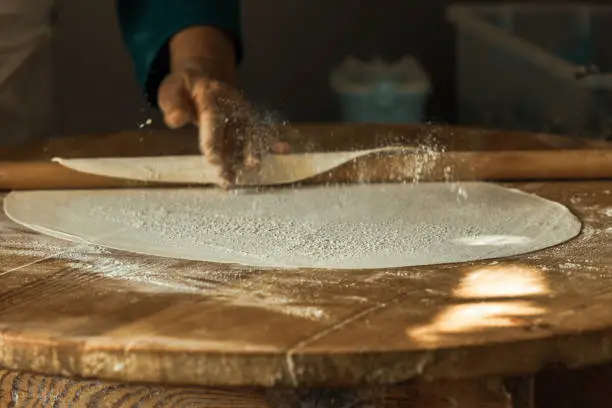 Photo of Woman's hand rolling dough for pancakes in Antalya, Turkey. SELECTVE FOCUS