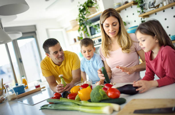 istock Young family cooking lunch at home. 1393685555