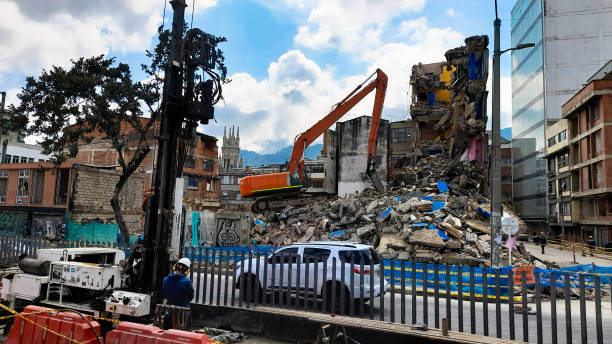 backhoe climbed on a building rubble pile - kentsel dönüşüm stok fotoğraflar ve resimler