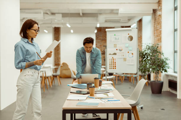 istock Two colleagues standing in the office and focused on work 1393686820