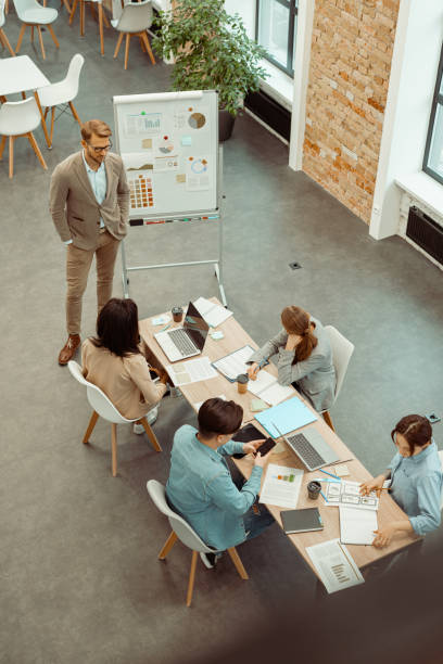 istock Leader standing near the flipchart and communicating with the team 1393686881