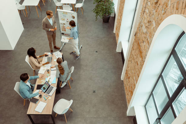 istock Young colleagues standing near flipchart in the office 1393686889
