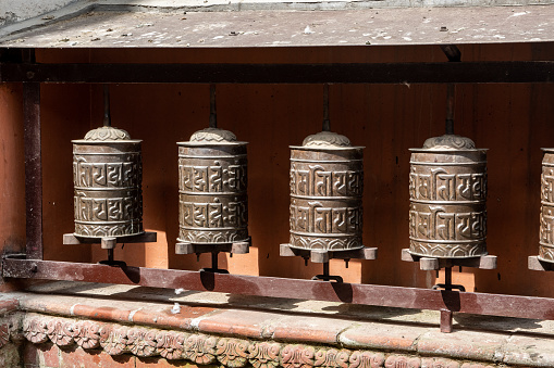 Bhaktapur, Madhyapur Timi, Kathmandu, Nepal - oct 28, 2019:  numerous prayer wheels are found along the outer perimeter of the Balkumari Buddhist temple, Thimi, Kathmandu Valley