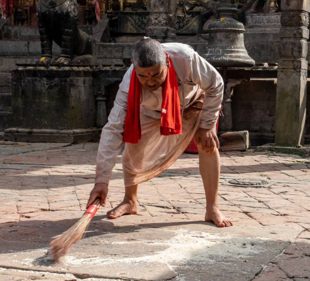 monje hindú limpia el patio del templo - changu narayan temple fotografías e imágenes de stock