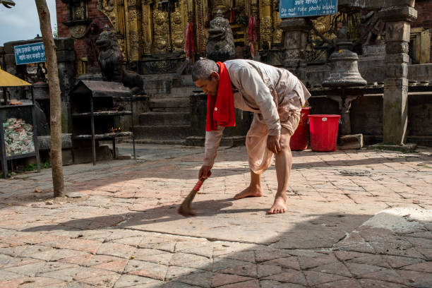 monje hindú limpia el patio del templo - changu narayan temple fotografías e imágenes de stock