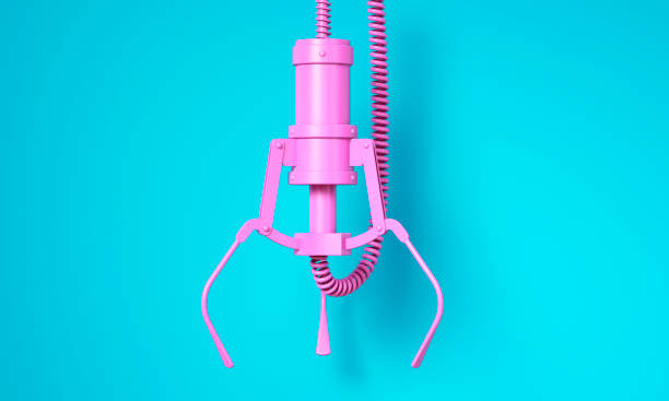 Pink robotic claw on blue background stock photo