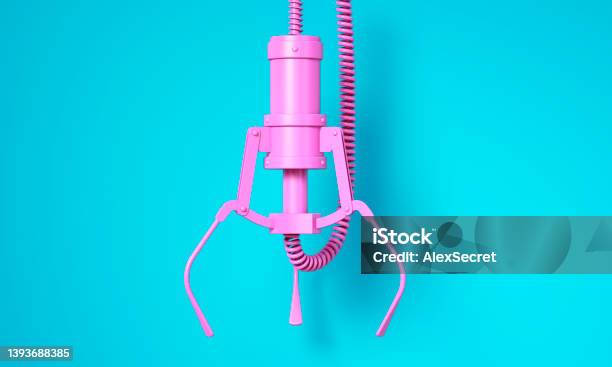 Pink Robotic Claw On Blue Background Stock Photo - Download Image Now - Mechanical Grabber, Toy Grabbing Game, Arcade