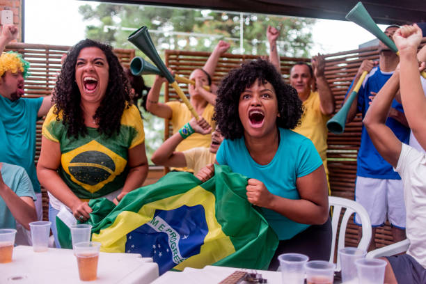 istock Soccer fans cheering for brazil 1393696721