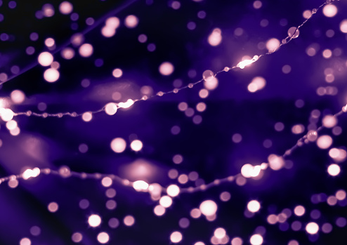 Sparkling bokeh on the violet pink background. Perfect for design. Christmas, New Year concept.