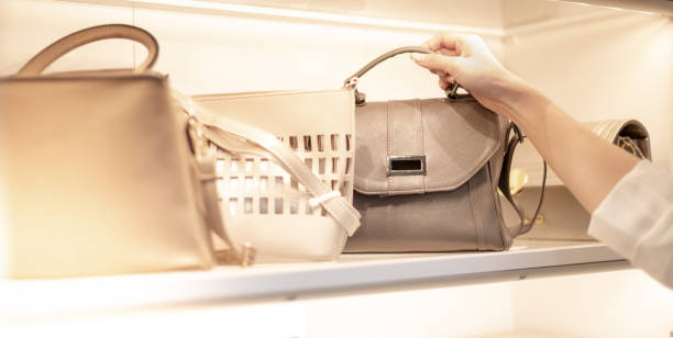 The female hand chooses a leather bag in a department store. stock photo
