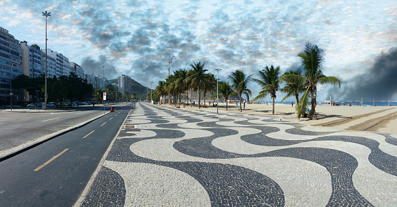 Copacabana Beach Rio de Janeiro boardwalk with palm trees and blue sky.