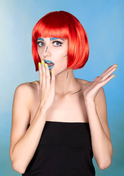 Portrait of young woman in comic pop art make-up style. Female in red wig on blue background