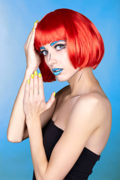 istock Female in red wig and in comic pop art make-up style on blue background 1393714621