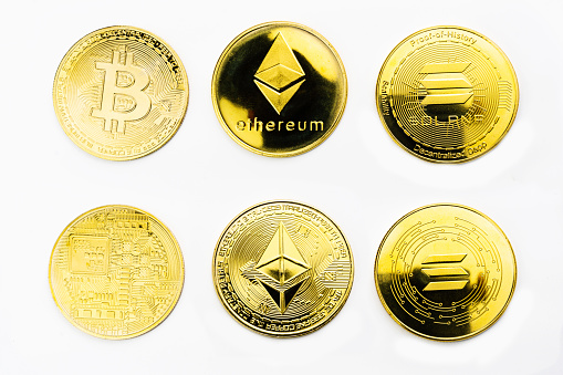 Closeup of a golden Bitcoin, Ethereum and Solana coins with white background. Cryptocurrency coin. Financial market.