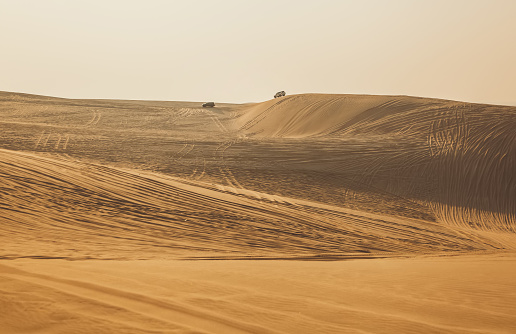 An empty road next to a desert in Dubai, UAE