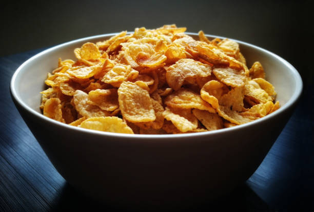 istock Crunchy cornflakes in a ceramic bowl on wood table. 1393726240