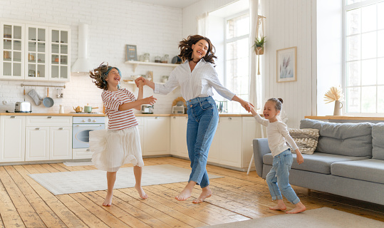 Mom and her daughters children girls are dancing. Family holiday and togetherness.