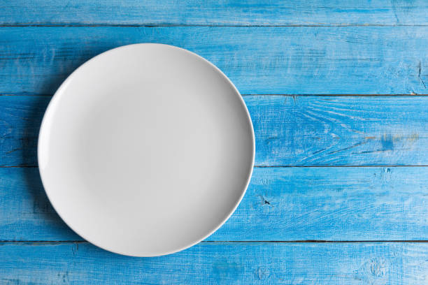 istock Directly above shot of clean empty plate on wooden table 1393736199