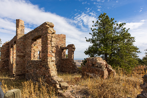 The ruins of an old chateau sit in a pine forest on top of a mountain in Colorado