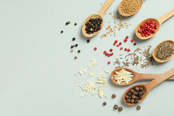 istock Wooden spoons with different spices on light gray background 1393739785